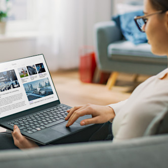 Woman reading news and accounting practice updates on her laptop.